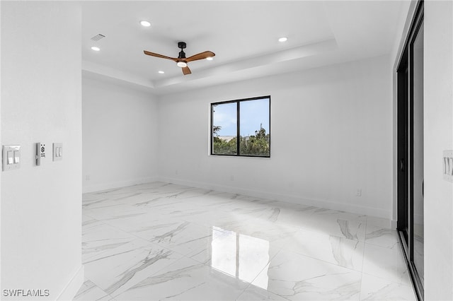 unfurnished room featuring a tray ceiling and ceiling fan