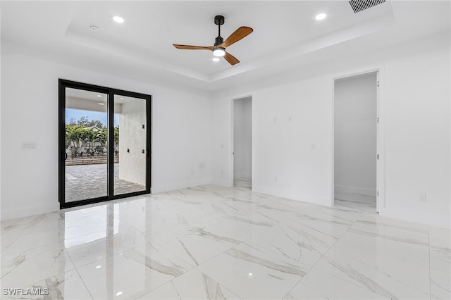 unfurnished room with a raised ceiling and ceiling fan