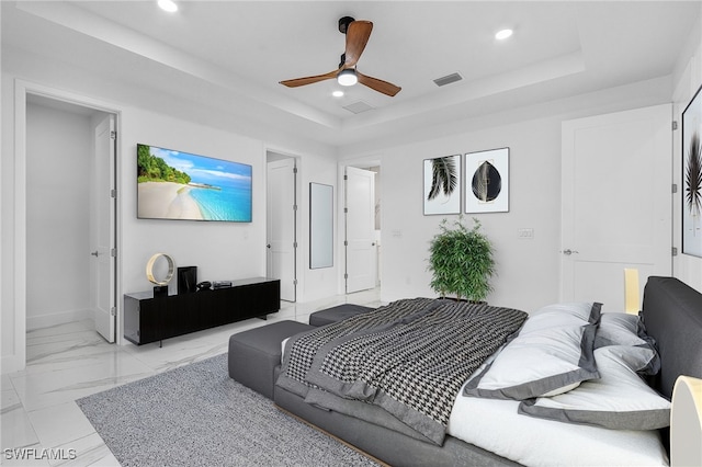 bedroom with ceiling fan and a raised ceiling