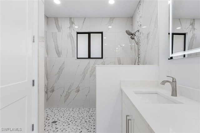 bathroom featuring vanity and tiled shower