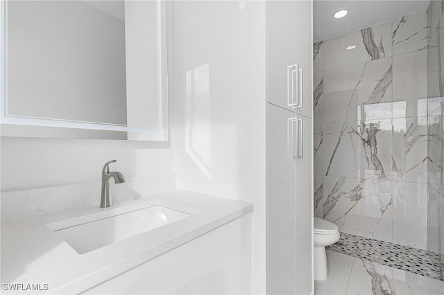 bathroom with vanity, a shower with shower door, and toilet