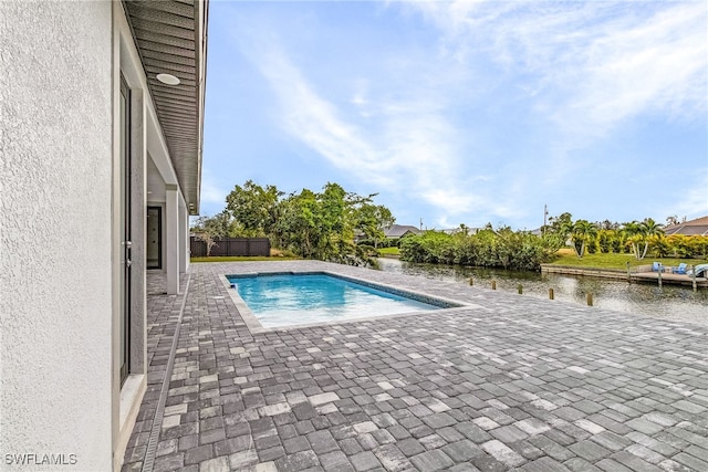 view of pool with a patio and a water view