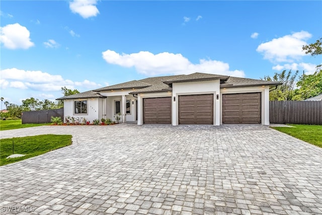 prairie-style home with a garage and a front lawn