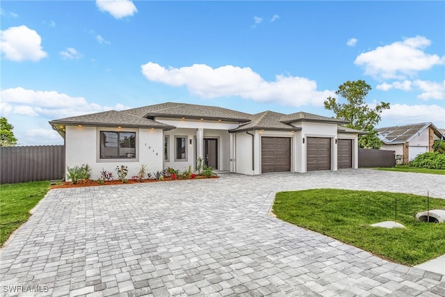 prairie-style home with a garage and a front lawn