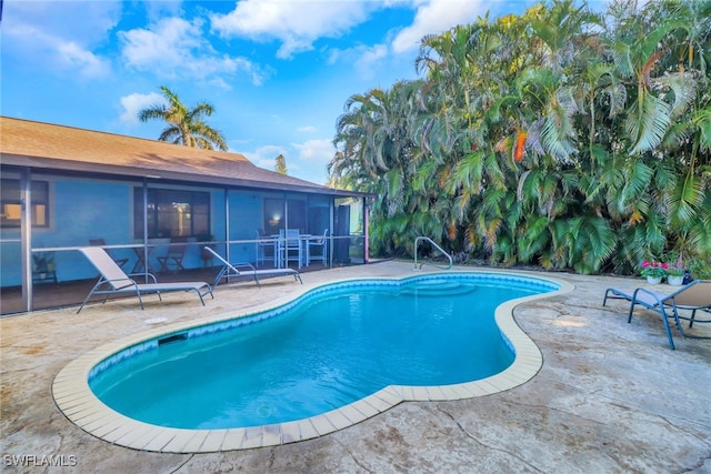 view of swimming pool featuring a sunroom and a patio area