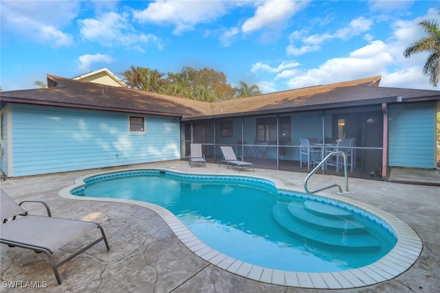 view of swimming pool with a sunroom and a patio