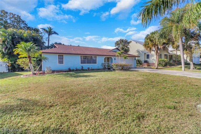 ranch-style house featuring a garage and a front lawn