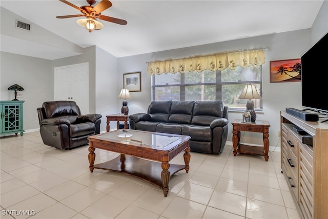 living room featuring lofted ceiling, ceiling fan, and light tile patterned flooring