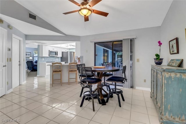 tiled dining room featuring vaulted ceiling and ceiling fan