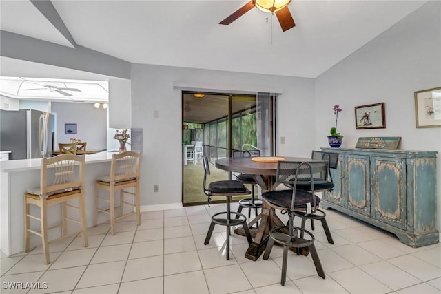 tiled dining area featuring ceiling fan and lofted ceiling