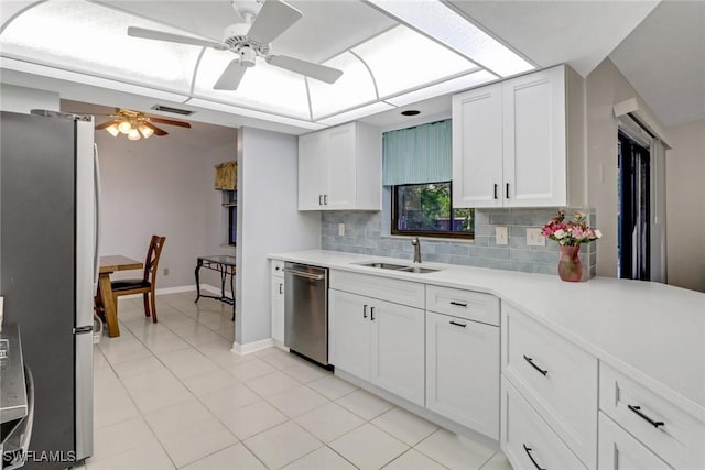 kitchen featuring sink, stainless steel appliances, white cabinets, light tile patterned flooring, and decorative backsplash