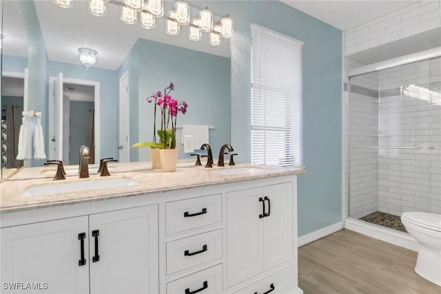 bathroom with vanity, wood-type flooring, toilet, and a shower with shower door