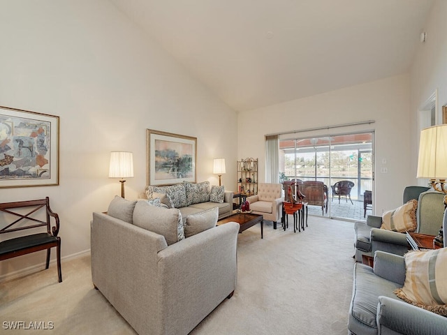 carpeted living room with high vaulted ceiling