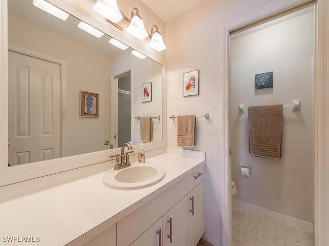 bathroom featuring vanity, a shower with shower door, and toilet