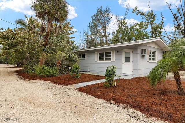 ranch-style home with a wall mounted air conditioner