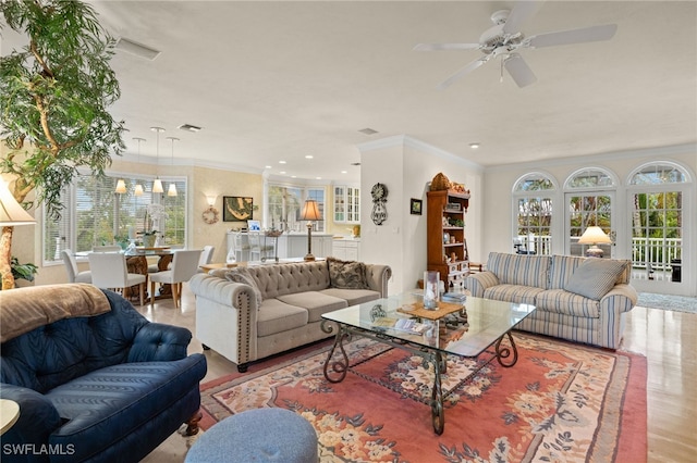 living room with ornamental molding, light hardwood / wood-style floors, and ceiling fan