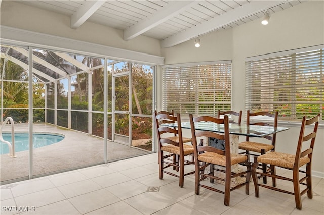 unfurnished sunroom featuring beamed ceiling, track lighting, and wood ceiling