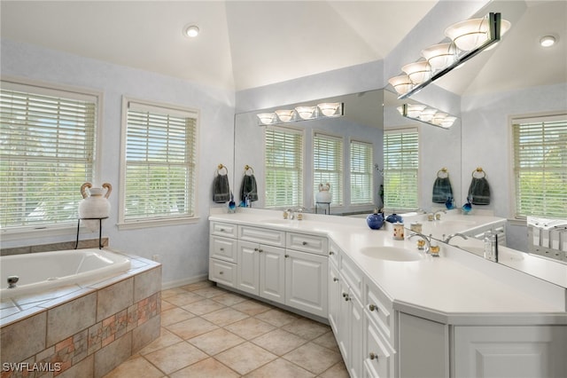 bathroom with vaulted ceiling, plenty of natural light, and vanity