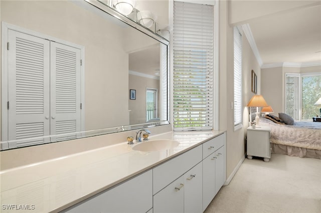 bathroom with connected bathroom, vanity, and ornamental molding