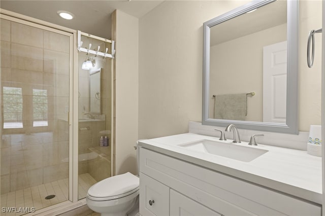 bathroom with vanity, an enclosed shower, and toilet