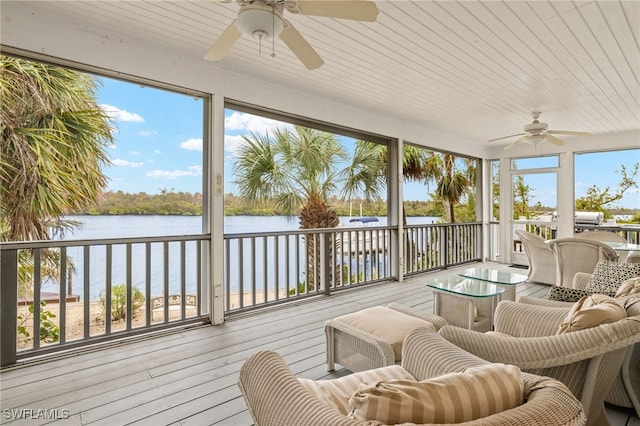 sunroom / solarium with a water view and a healthy amount of sunlight