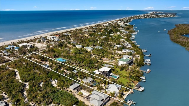 birds eye view of property featuring a water view and a beach view