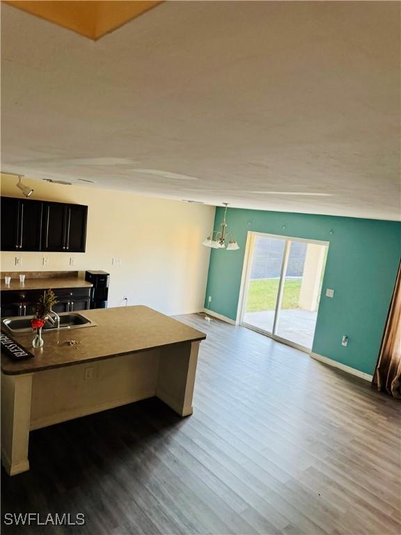 kitchen featuring a breakfast bar area, sink, hardwood / wood-style floors, and decorative light fixtures