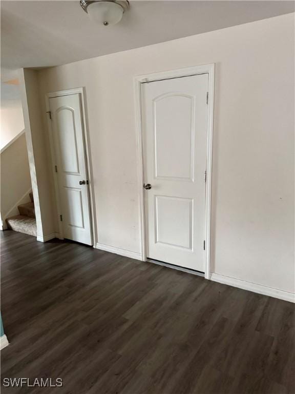 unfurnished room with dark hardwood / wood-style flooring