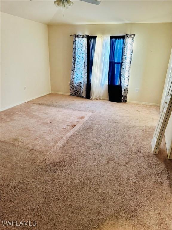 spare room featuring ceiling fan and carpet