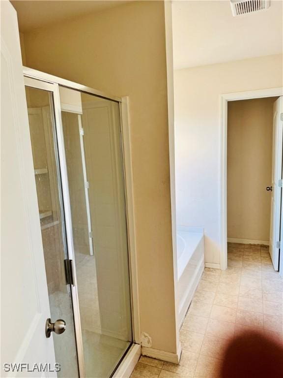 bathroom featuring tile patterned floors and shower with separate bathtub