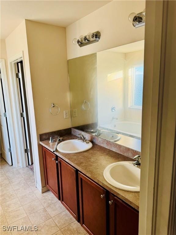 bathroom with tile patterned flooring, vanity, and a washtub