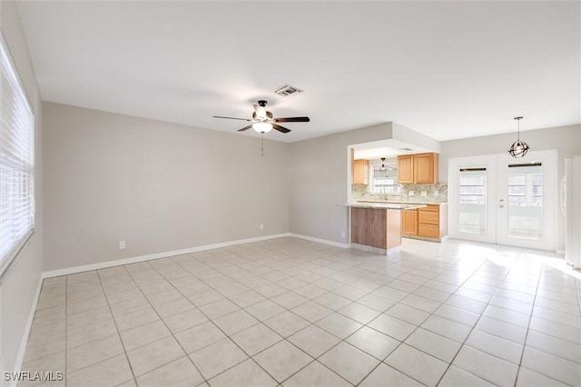 unfurnished living room with light tile patterned floors and ceiling fan