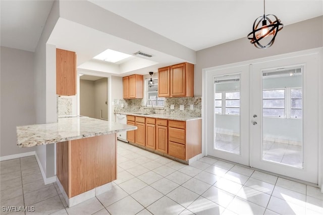 kitchen featuring pendant lighting, dishwasher, backsplash, french doors, and kitchen peninsula