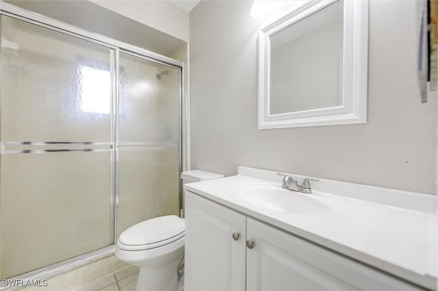 bathroom featuring tile patterned flooring, vanity, walk in shower, and toilet