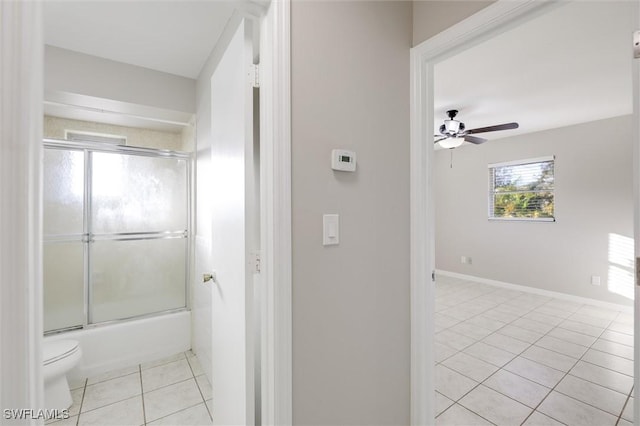 bathroom featuring combined bath / shower with glass door, tile patterned floors, ceiling fan, and toilet