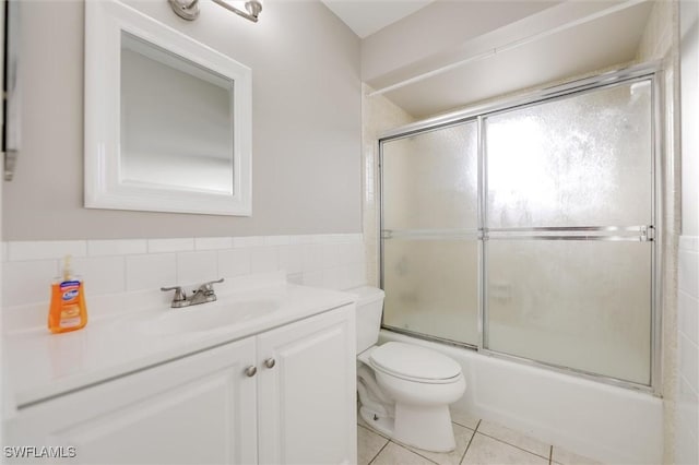 full bathroom featuring tile walls, tile patterned flooring, enclosed tub / shower combo, vanity, and toilet