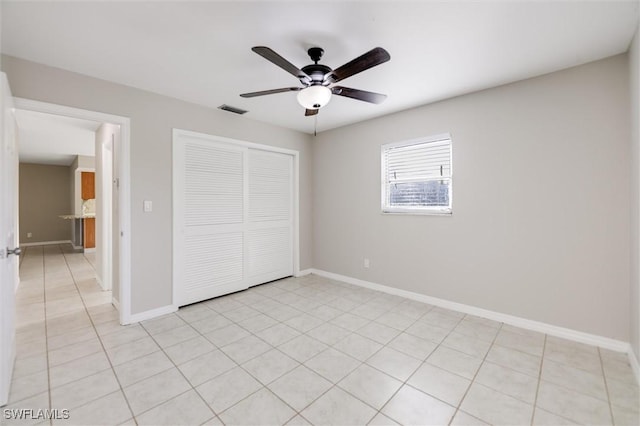 unfurnished bedroom featuring light tile patterned floors, ceiling fan, and a closet