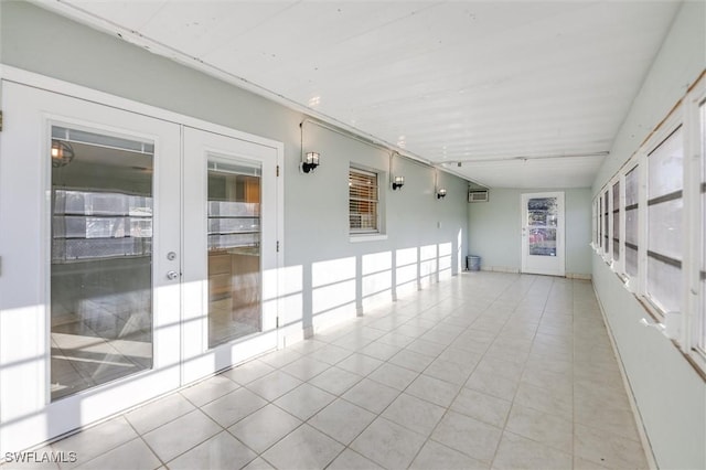 tiled empty room featuring a wall mounted AC and french doors