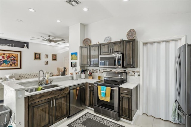 kitchen featuring appliances with stainless steel finishes, kitchen peninsula, sink, and dark brown cabinets