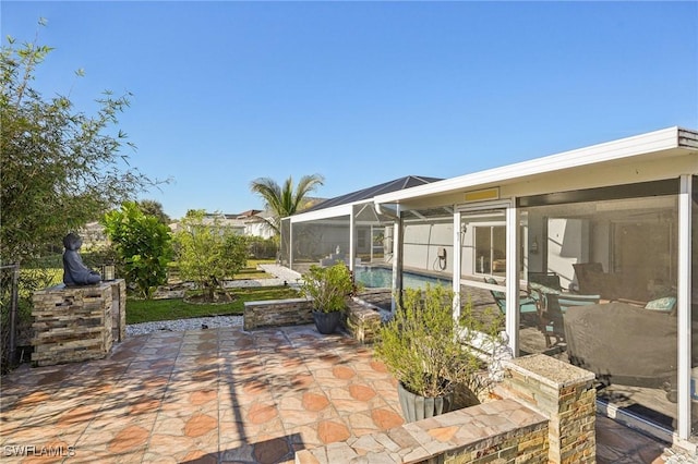 view of patio featuring a lanai