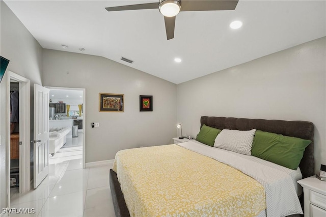 bedroom featuring light tile patterned flooring, ceiling fan, vaulted ceiling, and ensuite bath