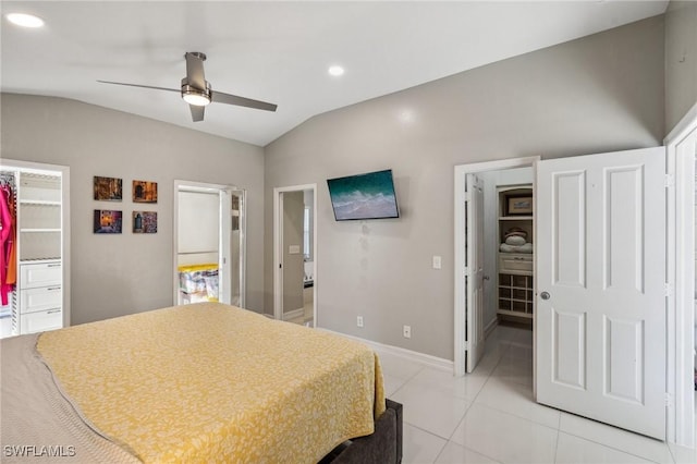 tiled bedroom featuring a spacious closet, vaulted ceiling, a closet, and ensuite bathroom