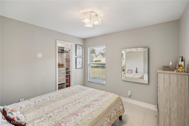 bedroom with a walk in closet and light tile patterned floors