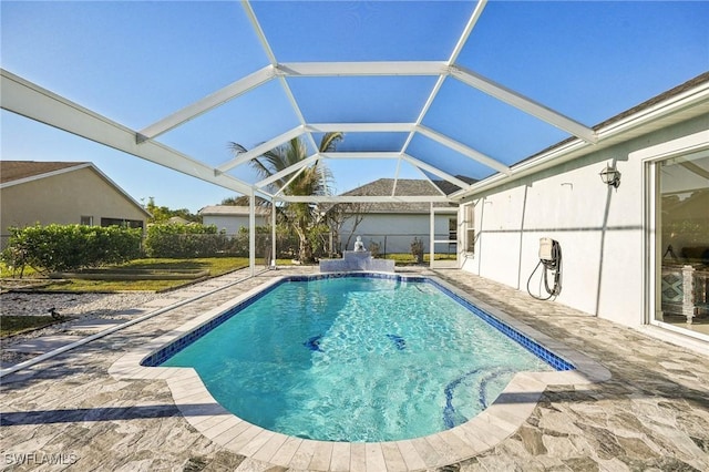 view of pool with a patio area and glass enclosure