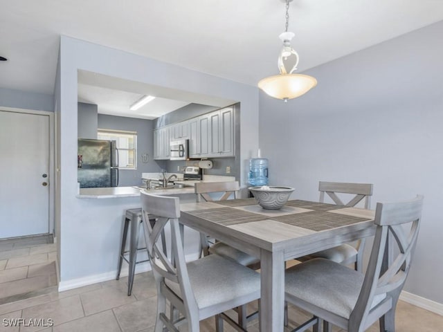 dining space with sink and light tile patterned floors