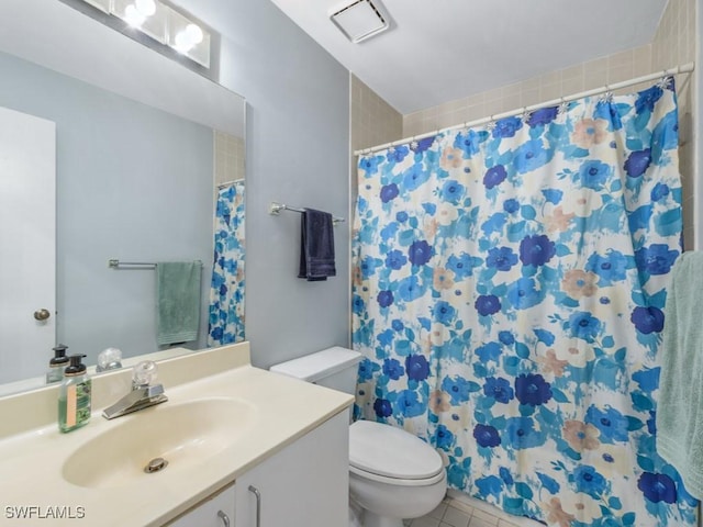 bathroom featuring vanity, tile patterned floors, and toilet