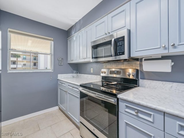 kitchen featuring white cabinetry, stainless steel appliances, and light tile patterned floors