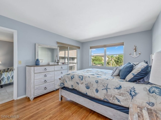 bedroom with access to exterior and light wood-type flooring