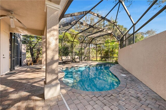 view of swimming pool featuring an outdoor living space, a patio, a lanai, and ceiling fan