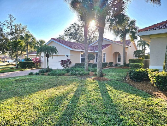 mediterranean / spanish-style house with a garage and a front yard